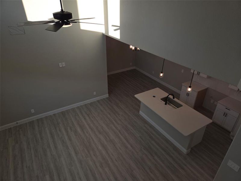 Empty room featuring ceiling fan, sink, a high ceiling, and dark hardwood / wood-style floors