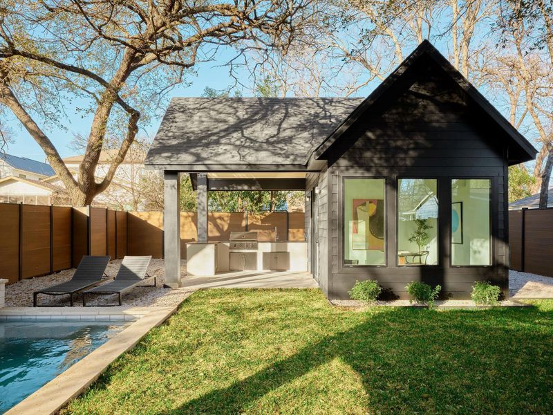 Back of house featuring a fenced backyard, area for grilling, an outdoor pool, a patio area, and roof with shingles