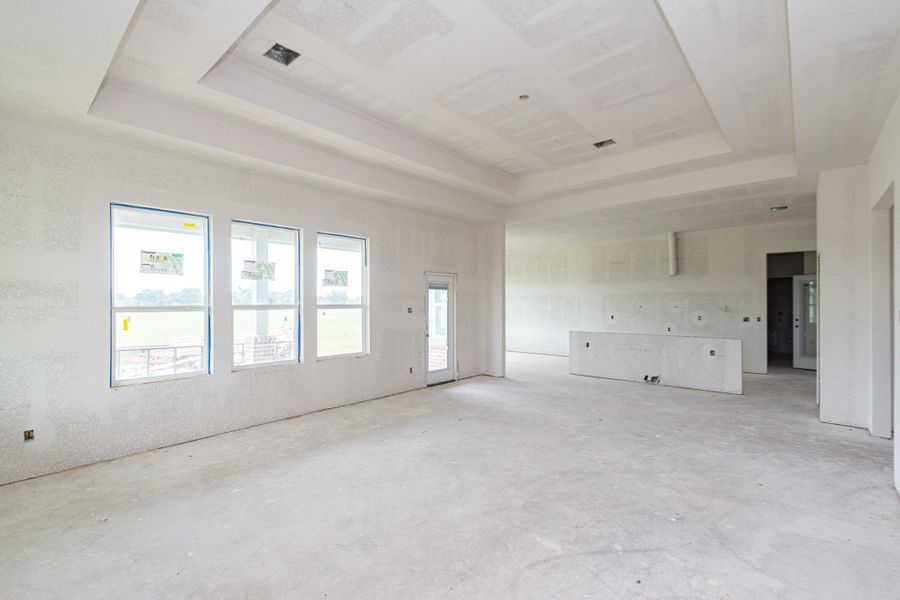 Spacious and bright open-concept living area with large windows, high ceilings, and an unfinished interior ready for customization. Spacious and bright open-concept living area with large windows, high ceilings, and an unfinished interior ready for customization.