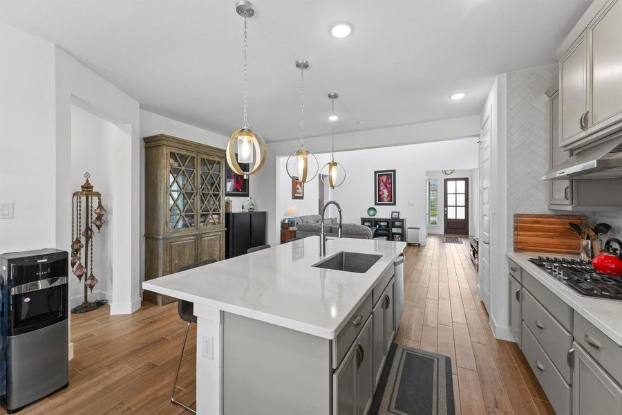 This view highlights the open-concept design of the main living area, connecting the kitchen, living room, and entryway. It showcases the builder's commitment to creating a modern, flowing floor plan.