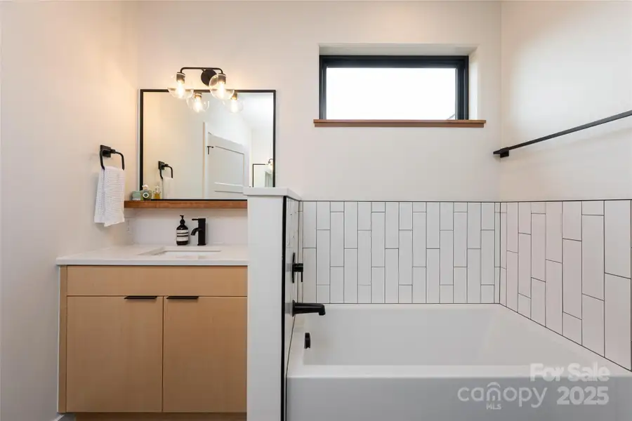 Dual vanities with tile-surround tub. Dual vanities with tile-surround tub.