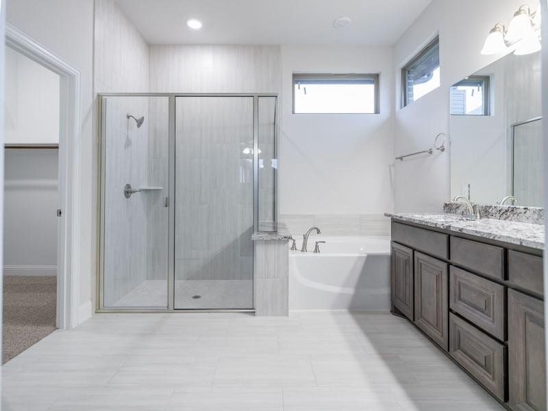 Bathroom featuring vanity and shower with separate bathtub