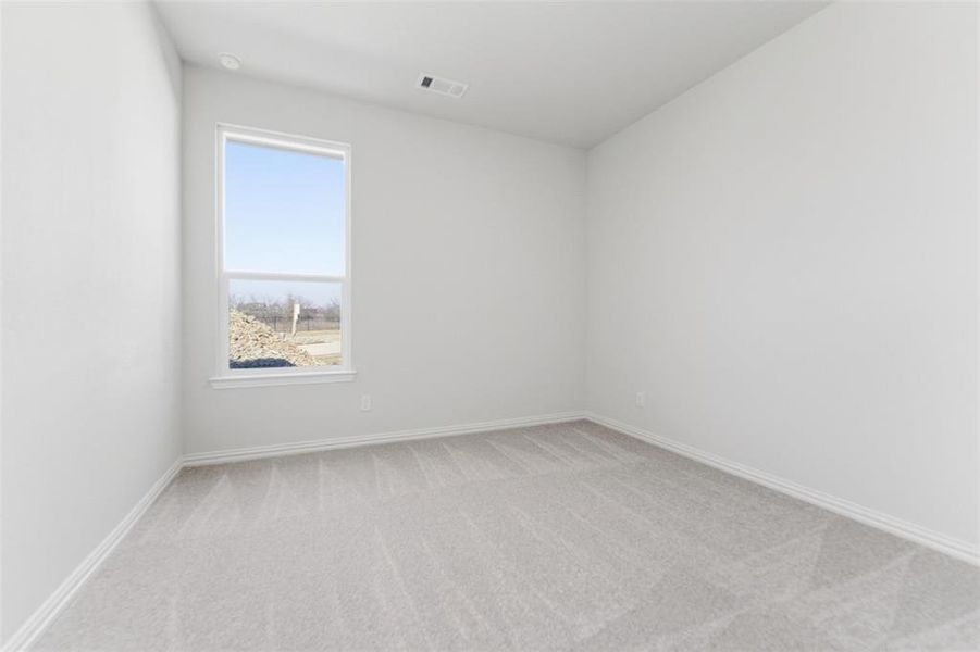 Spare room featuring light colored carpet and baseboards