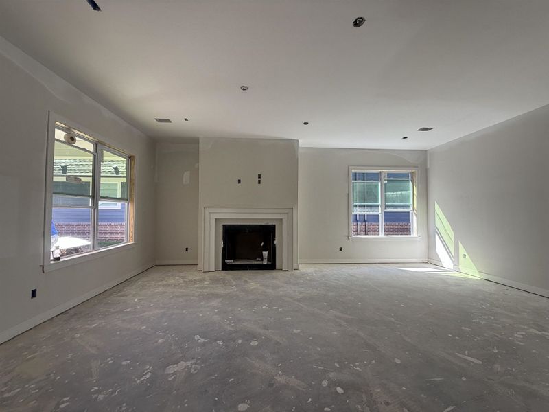 Unfurnished living room featuring baseboards and a fireplace