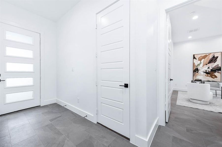 View from the stairs. Front door straight ahead, garage to the right and then on the far right is the entry to the study.