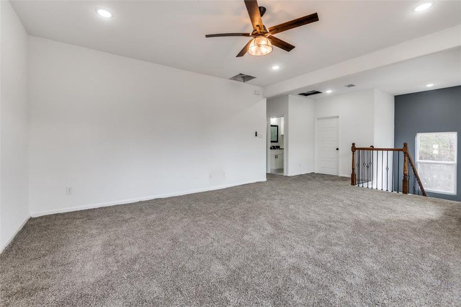 Carpeted empty room featuring ceiling fan