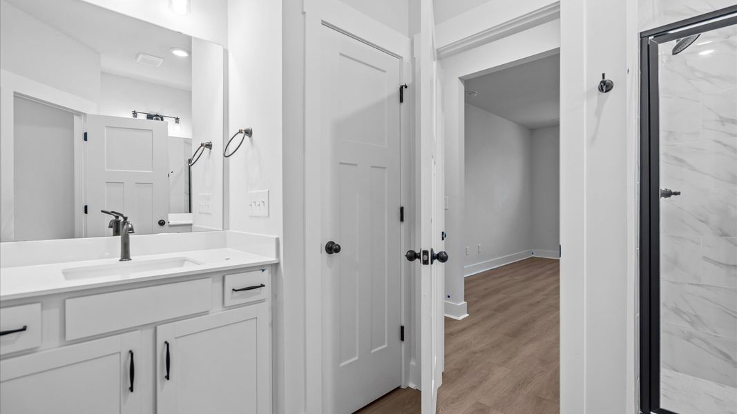 Elegant primary bathroom with tiled walk-in shower and double vanity at Silo Ridge by DRB Homes in Anderson, SC