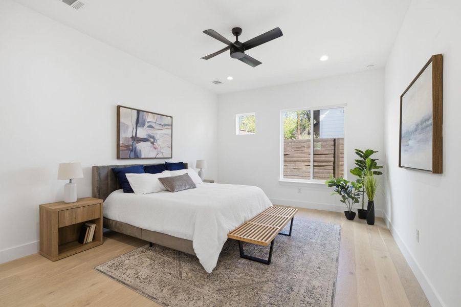 Bedroom with light wood-style flooring, ceiling fan, and recessed lighting