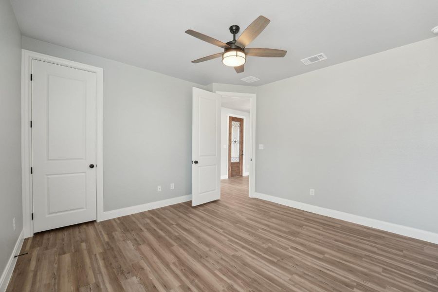 Bedroom 2 featuring visible vents, ceiling fan, baseboards, and wood finished floors