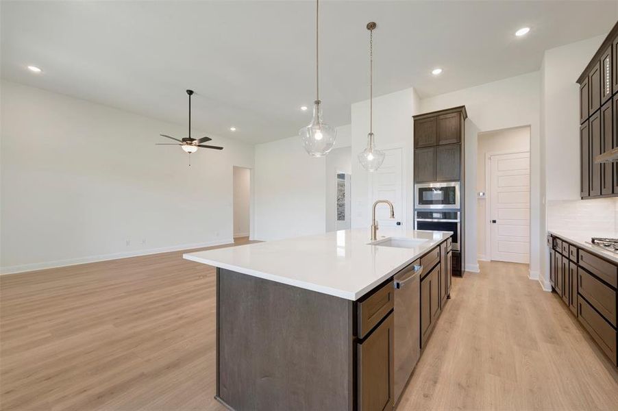 Kitchen island featuring a white countertop, undermount sink, and stainless steel dishwasher Kitchen island featuring a white countertop, undermount sink, and stainless steel dishwasher