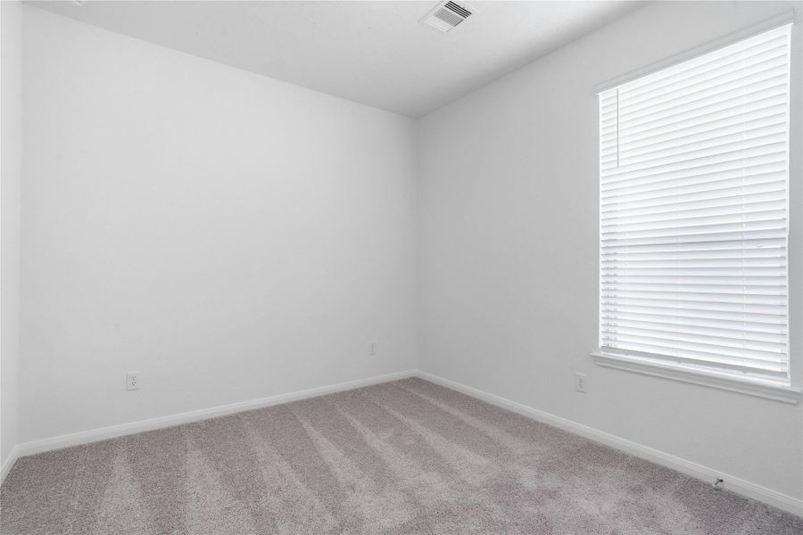 Light-filled secondary bedroom complete with cozy carpet flooring, ample closet space, and a large window wth fitted blinds. Light-filled secondary bedroom complete with cozy carpet flooring, ample closet space, and a large window wth fitted blinds.