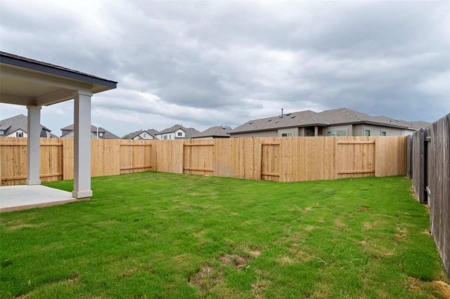Fenced backyard with a residential view Fenced backyard with a residential view
