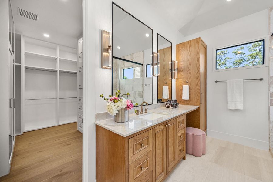 Large walk-in closet offers custom wardrobe built-ins w/ adjustable shelving for bags & shoes, glass front cabinets, 2 full size wall hung mirrors & separate mud room area w/ bench. Large walk-in closet offers custom wardrobe built-ins w/ adjustable shelving for bags & shoes, glass front cabinets, 2 full size wall hung mirrors & separate mud room area w/ bench.