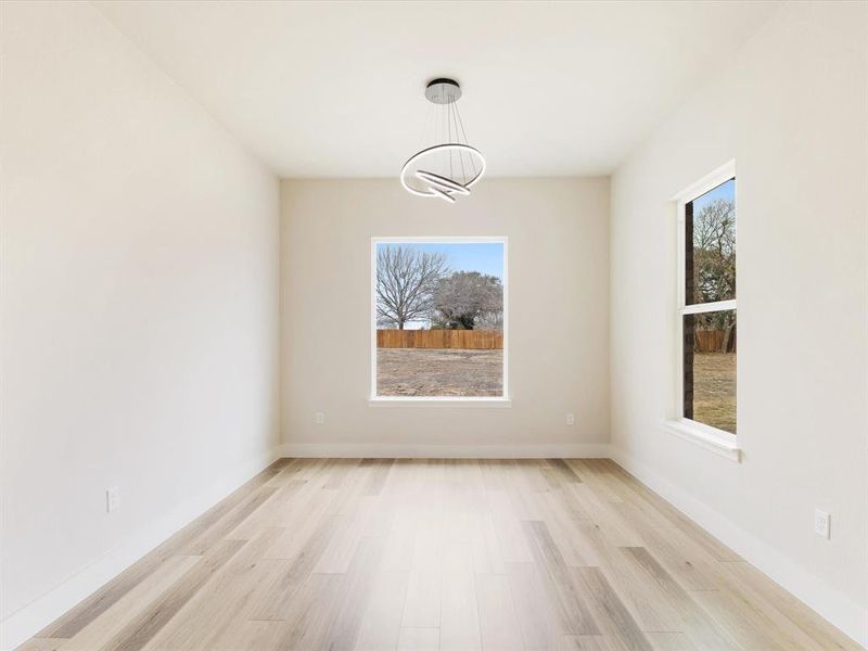 Unfurnished dining area featuring light wood-style floors and baseboards