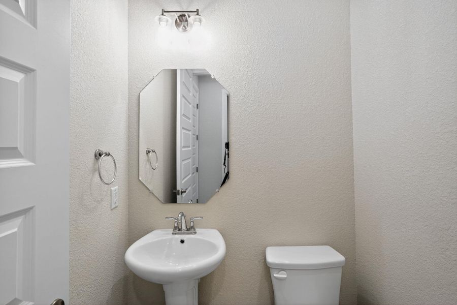 Half bathroom featuring a textured wall and a sink Half bathroom featuring a textured wall and a sink