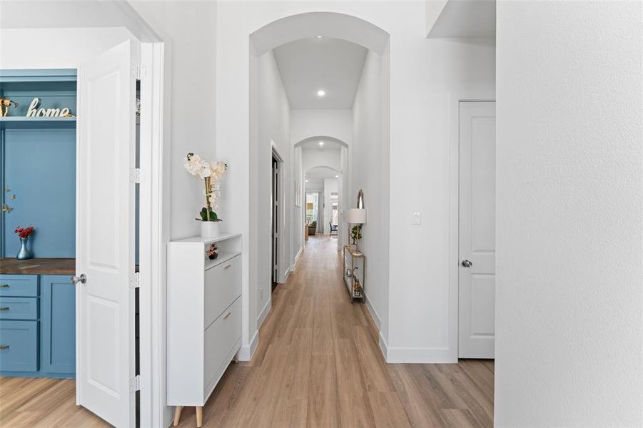 Hall with arched walkways, light wood finished floors, and recessed lighting Hall with arched walkways, light wood finished floors, and recessed lighting