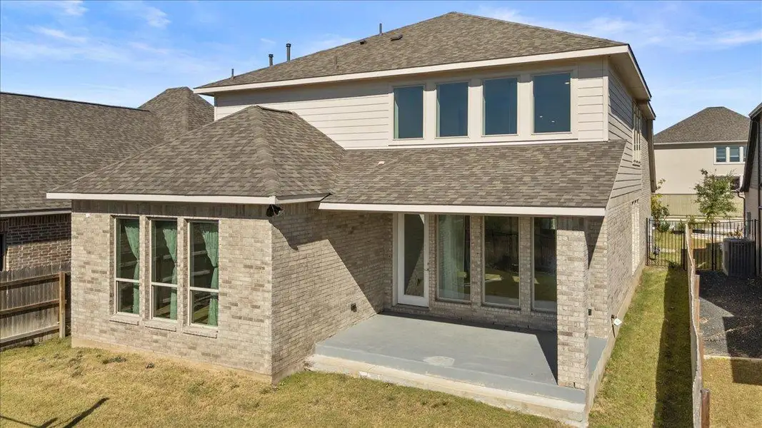 Back of house with a fenced backyard, a patio area, a shingled roof, and brick siding Back of house with a fenced backyard, a patio area, a shingled roof, and brick siding