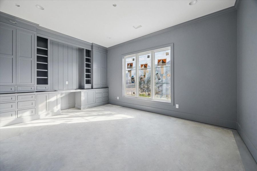 STUDY - Custom gray built ins wrap the room with extensive cabinetry, shelving, and a dedicated desk area, creating a highly functional space for work/study. Tall ceilings, soft natural light, and a cohesive color palette allow the room to adapt easily as needs change over time. -- Construction as of 1/5/26
