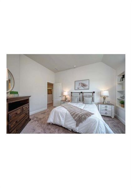 Bedroom featuring lofted ceiling and light colored carpet