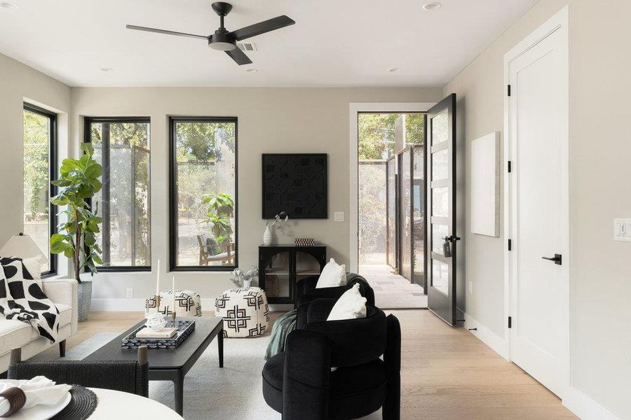 Living room featuring light wood-type flooring, a ceiling fan, and recessed lighting