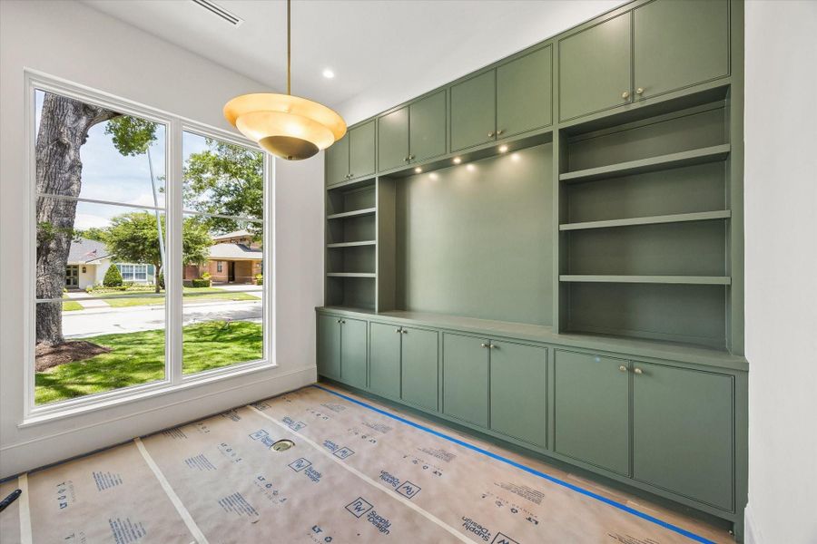 The study with built-ins, a chandelier, a beautiful paint color, and a generously sized window. The room will be finished in the same color palette throughout.