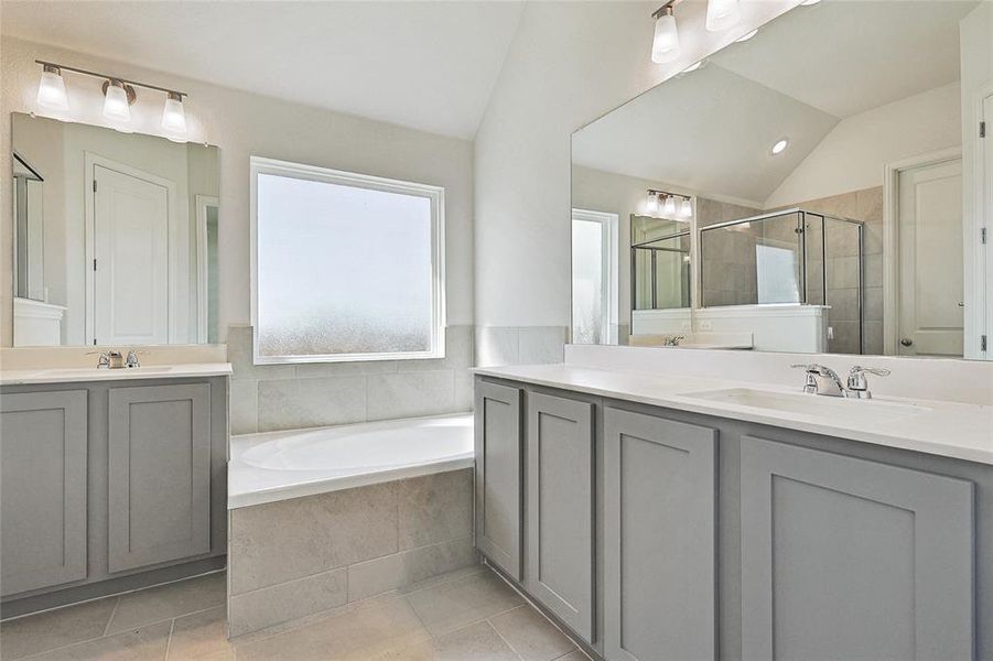 Bathroom with vanity, lofted ceiling, independent shower and bath, and tile patterned floors