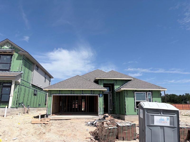 A new construction home with an attached garage under a bright sky. A new construction home with an attached garage under a bright sky.