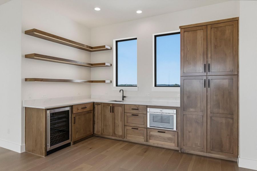 Upstairs game room bar with bev fridge, microwave and ample storage