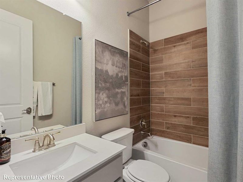 Full bathroom featuring tiled shower / bath combo, toilet, and vanity