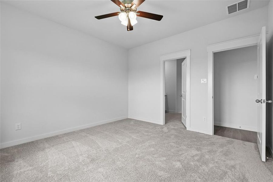 Unfurnished bedroom with carpet floors, baseboards, and a ceiling fan Unfurnished bedroom with carpet floors, baseboards, and a ceiling fan