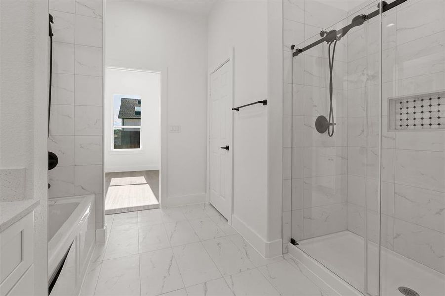 Full bath featuring a stall shower and marble finish flooring