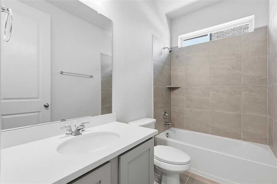Bathroom featuring a vanity with an integrated sink, polished chrome faucet, and grey cabinetry