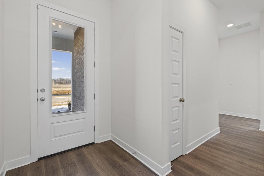 Doorway with wood finished floors and recessed lighting