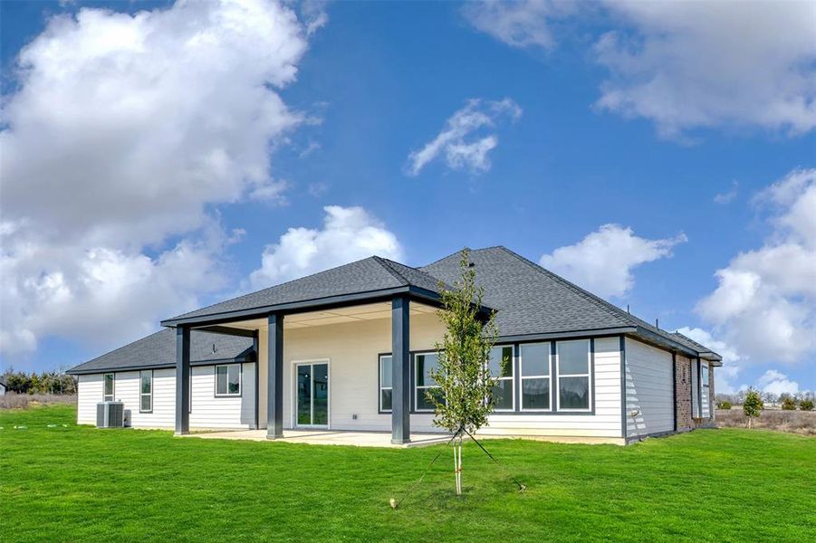Back of property featuring a patio, a lawn, roof with shingles, and cooling unit