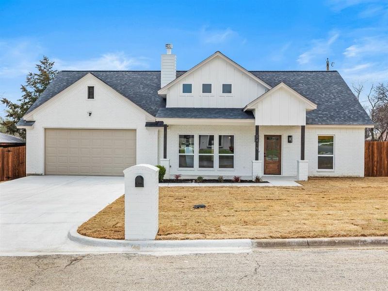 Modern farmhouse style home with fence, driveway, an attached garage, a chimney, and board and batten siding