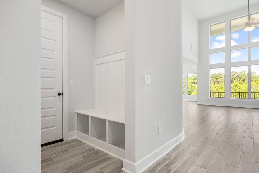 Mudroom featuring wood tiled floors, ceiling fan, and a high ceiling
