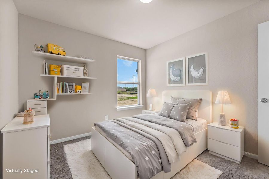 A cozy bedroom features carpeted flooring and a window offering views of the surrounding landscape.