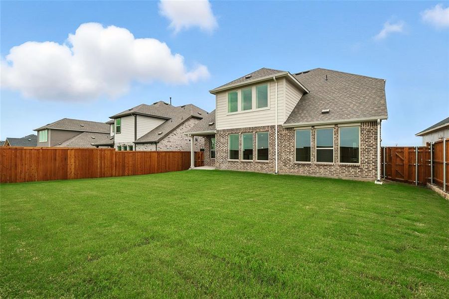 Rear view of house with a patio area, brick siding, a fenced backyard, and a shingled roof