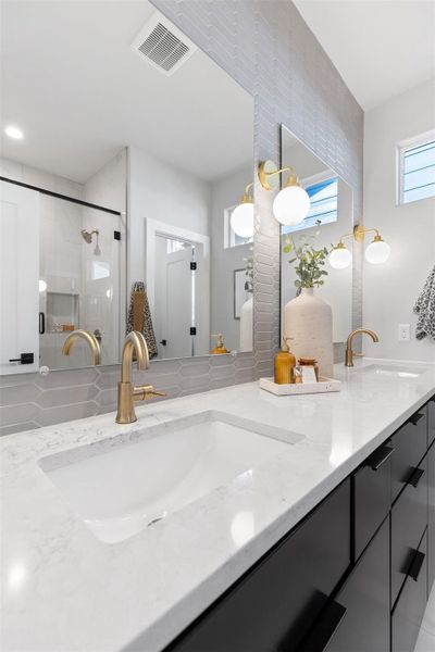 Full bath featuring double vanity and a shower stall