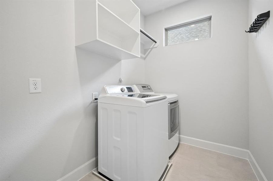 Dedicated utility space featuring light neutral walls, baseboard trim, and a high window