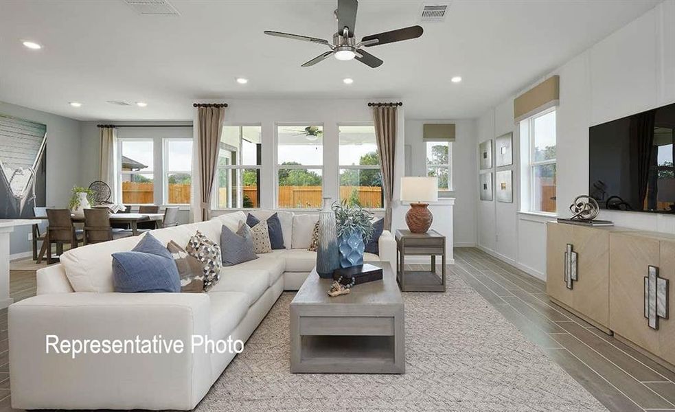 Spacious living area featuring plank-style flooring, a ceiling fan, and recessed lighting