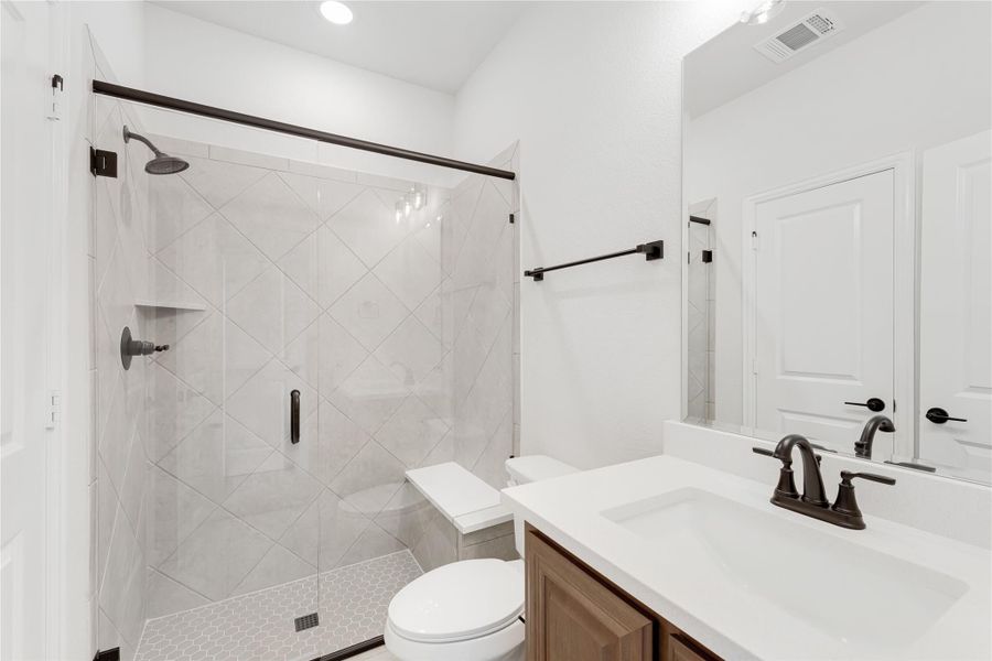 Bathroom with glass walk-in shower, white tile, wood vanity, and dark bronze fixtures Bathroom with glass walk-in shower, white tile, wood vanity, and dark bronze fixtures