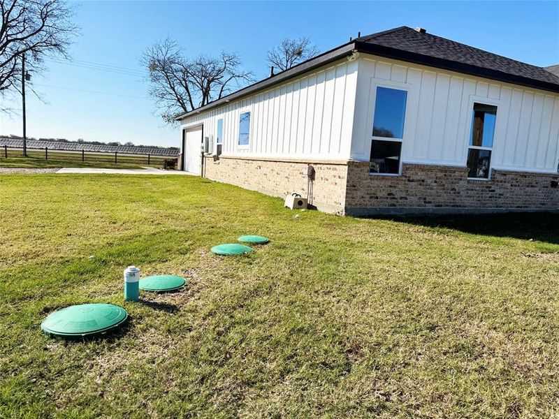 View of side of home with board and batten siding, brick siding, and a garage