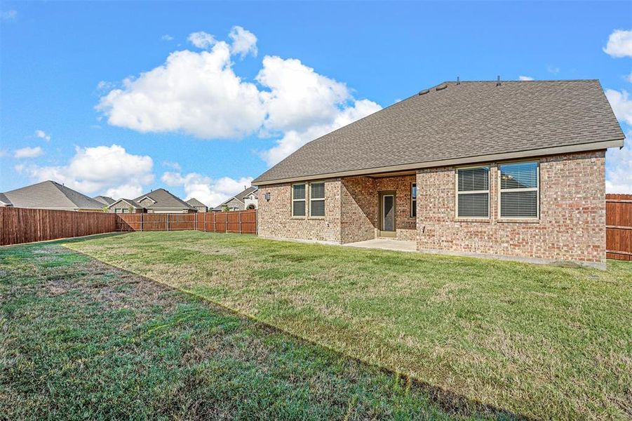 Rear view of property with a patio area and a lawn