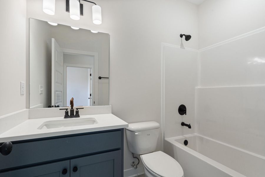 Vanity with a white countertop, undermount sink, and matte black faucet