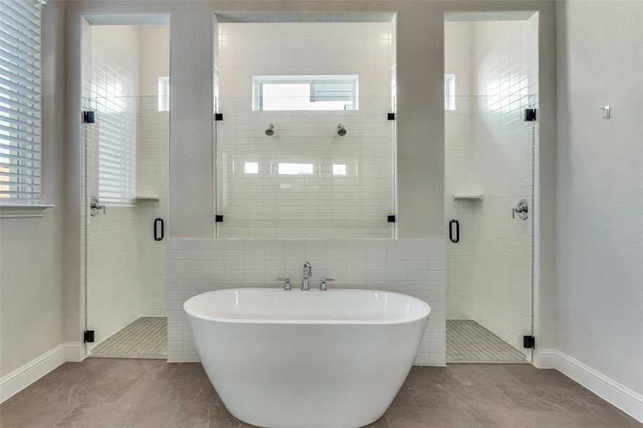 Bathroom featuring a freestanding bath, a shower stall, and tile walls Bathroom featuring a freestanding bath, a shower stall, and tile walls