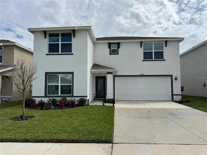 Front exterior of a new home in Zephyr Ridge, Zephyrhills, FL, highlighting curb appeal (Image 19).