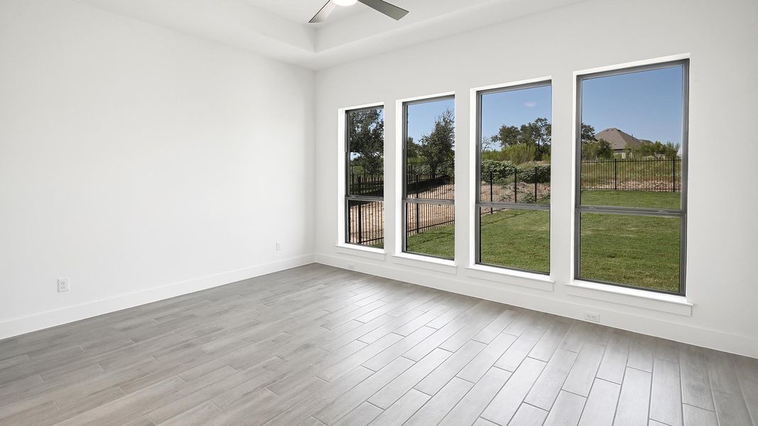 Empty room featuring light wood-style floors and a ceiling fan Empty room featuring light wood-style floors and a ceiling fan