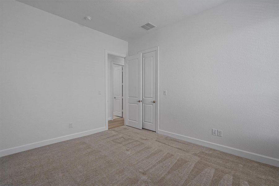 Neutral tone carpeting provides a soft foundation for this room, complemented by crisp white walls and white baseboards
