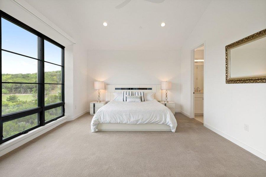 Spacious room with expansive black-framed windows showcasing exterior greenery
